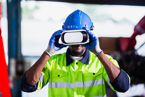 engineer man african american using virtual reality glasses. goggles innovation future watching education internet. Work is controlled through a modern digital system.