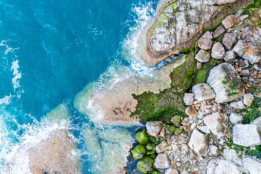 Beach scene - turquoise transparent ocean and  a white sand beach. Bali, Melasti beach aerial view.