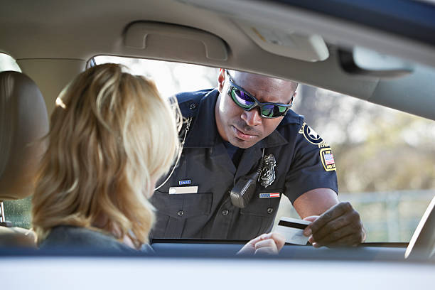 Woman pulled over by police Woman driving car, pulled over by African American police officer (20s). black men with blonde hair stock pictures, royalty-free photos & images