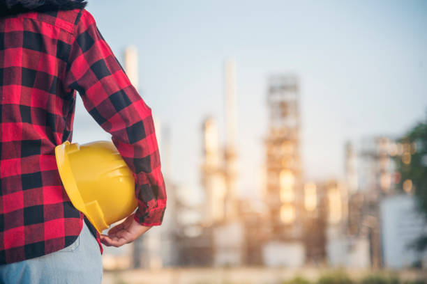 istock Woman worker hands holding hardhat yellow work helmet Construction Engineer. Refinery woman worker oil petro industry hand hold yellow worker helmet hard hat. Refinery industry engineer manufacture 1705909853