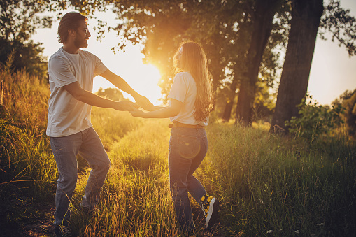 Man and woman, beautiful young couple dancing in nature together.