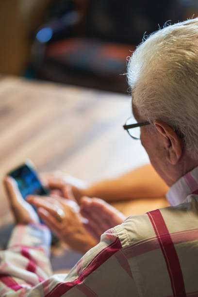 istock Rear view of an older man using the smart phone. 1705918130