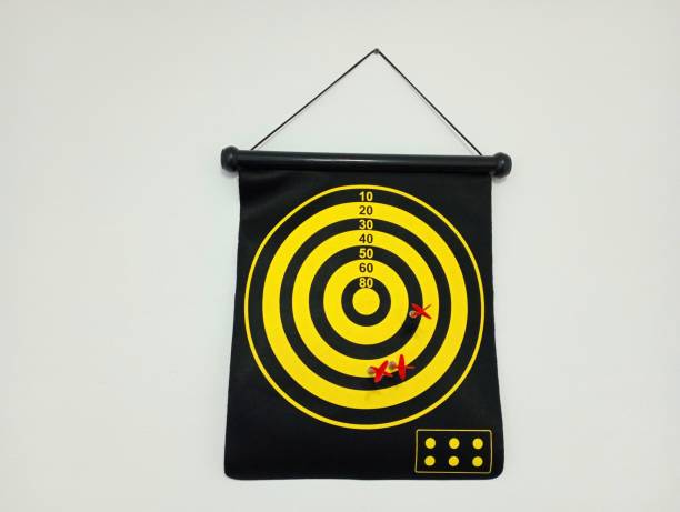 istock A magnetic dart board with attached darts hangs on the white wall. 1705937384