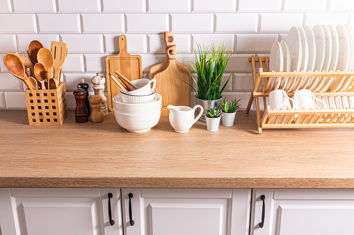 Beautiful kitchen background with different items and kitchen utensils made of eco-friendly materials. wooden countertop, white brick wall