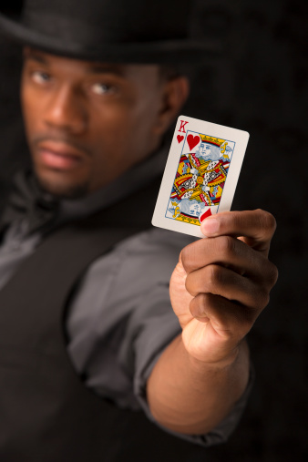 Card shark the king of hearts. This stock image has a vertical composition and a dark vintage wallpaper background.