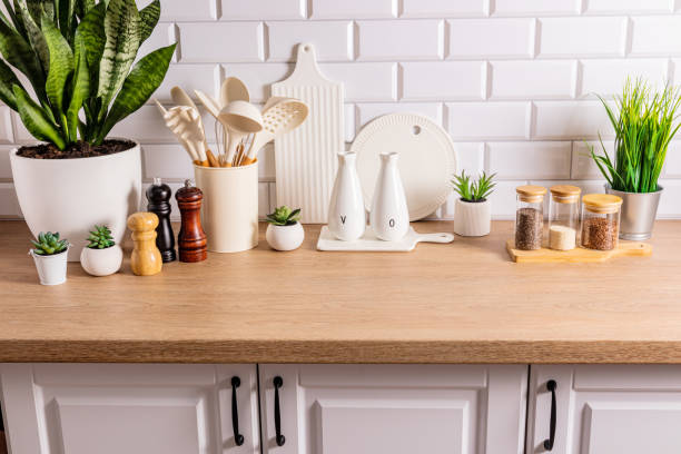 istock White ceramic utensils and kitchen utensils on a wooden countertop in an eco-friendly kitchen with green indoor plants. Cozy house 1705942112