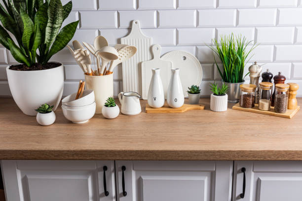 istock Beautiful kitchen background of a modern countertop with a set of various kitchen utensils, green plants in pots. Eco style. natural materials. 1705942168