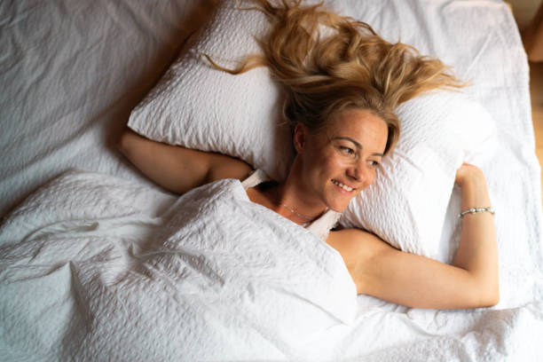 istock Happy woman resting on bed 1705951315