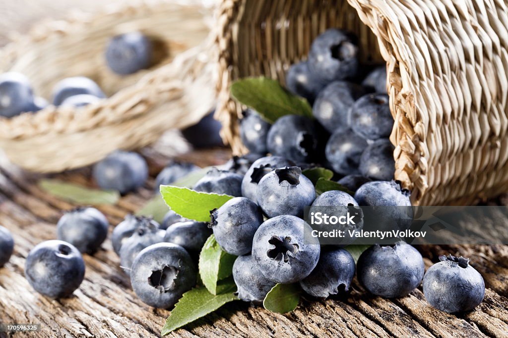 Blueberries have dropped from the basket Blueberries have dropped from the basket on an old wooden table. Basket Stock Photo