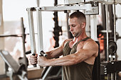 Bodybuilder Working Out On Chest Fly Machine In Gym