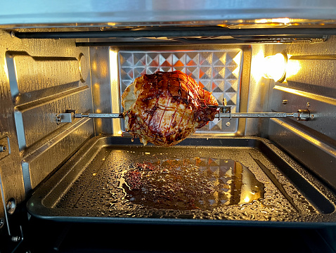 Rolled loin of pork on spit in air fryer oven