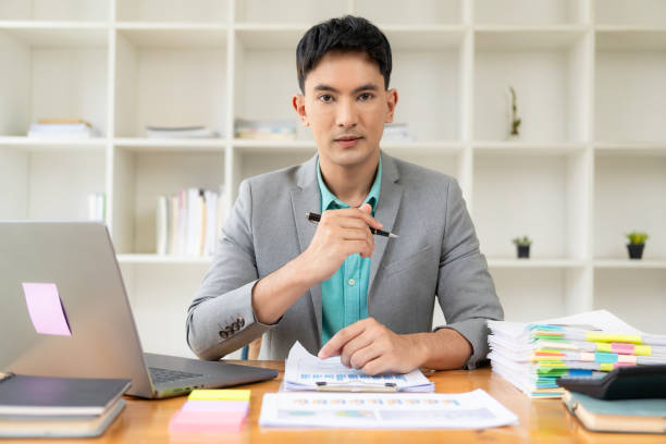 istock Asian businessman working at office with laptop and documents on table Work in the workplace, business documents, financial planning concepts 1706010559