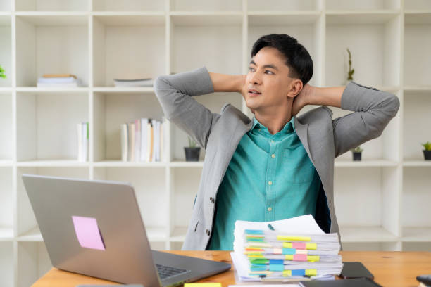 istock Businessman relaxing caused by working on a laptop computer for a long time. Stack of documents. Office syndrome. neurological disease 1706015764