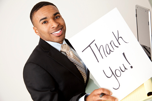 African Descent Business man suit  white background holding thank you sign