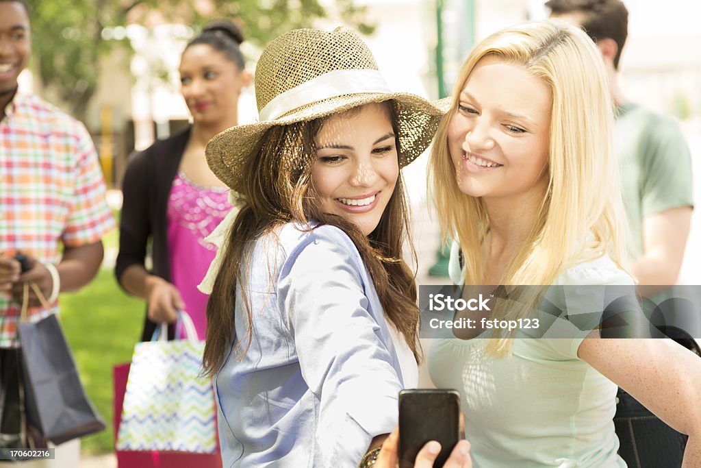Technologie: Jeunes femmes amis shopping, prenant des autophotos sur téléphone portable. - Photo de 18-19 ans libre de droits