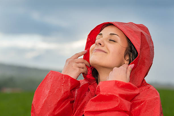 Jovem mulher desfrutar de raindrops no rosto dela - foto de acervo