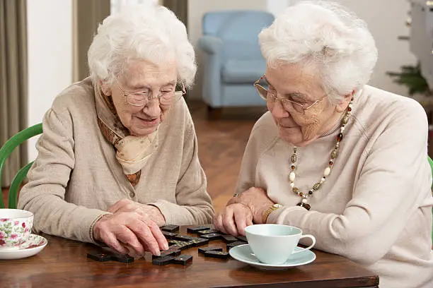 Photo of Two senior women playing dominoes at day care center