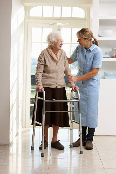 istock Carer Helping Elderly Senior Woman Using Walking Frame 170602737