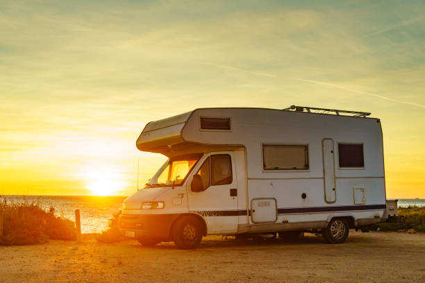 istock Camper car on beach at sunrise 1706027965