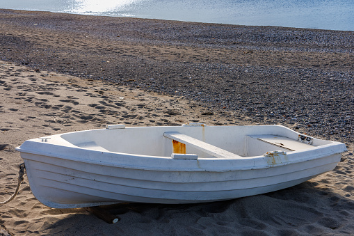 Beach with a small fishing boat in Rometta, Sicily, Italy