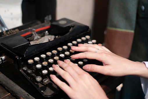 female person typing text using and old typewriter machine