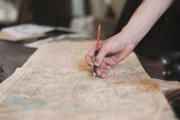 istock person's finger pointing on the old map to go to the destination 1706057481