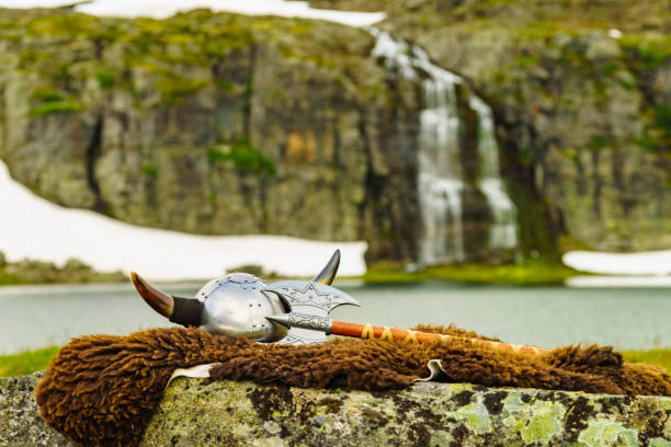 Viking helmet with axe on lake shore in Norway. Tourism and traveling concept