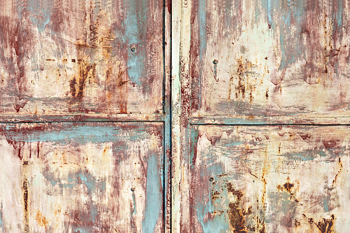 An old metal door background, painted and displaying patinated metal