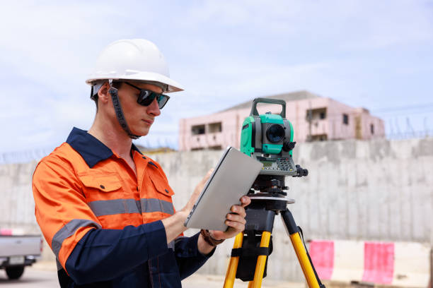 istock Engineer use theodolite equipment and looking blueprints on tablet construction project for route surveying 1706069713