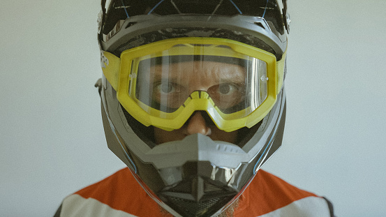 Man wearing a motocross enduro helmet on white background
