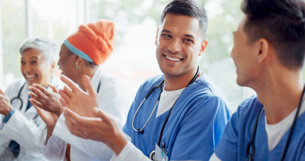 healthcare, meeting and applause with a doctor man and woman team cheering in a hospital boardroom. doctors, nurses and medical with a medicine group clapping during a seminar or training workshop - training business seminar clapping imagens e fotografias de stock