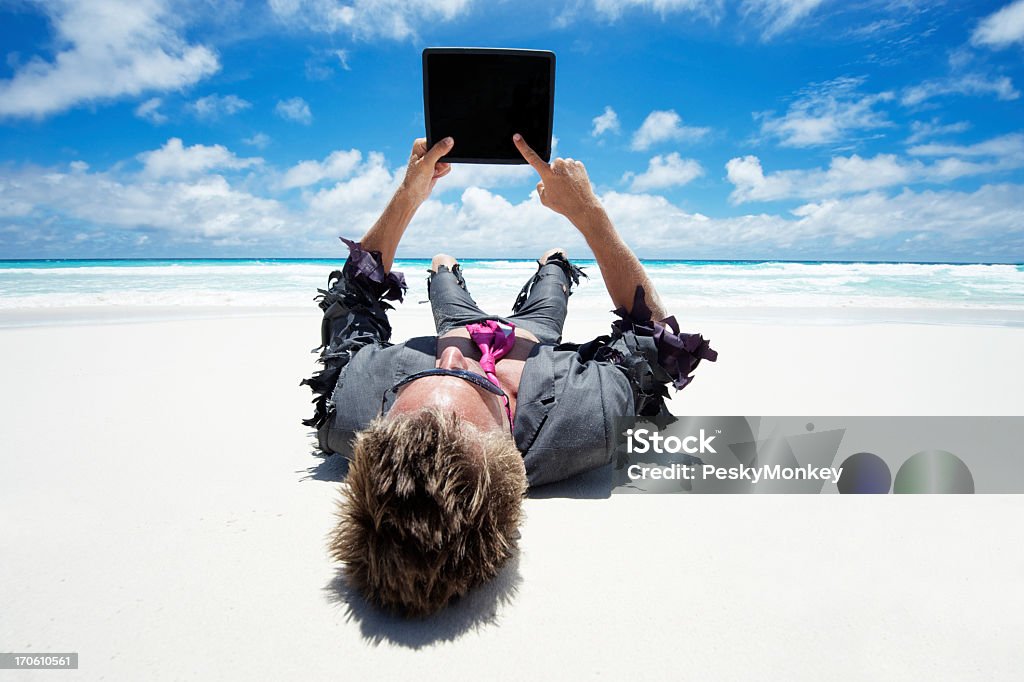 Castaway Empresário usando um Tablet em branco na praia ao ar livre - Foto de stock de Confusão royalty-free