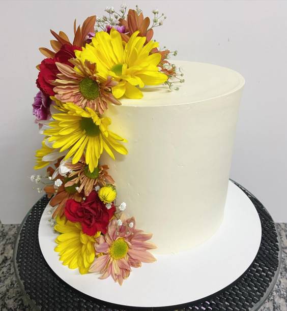 istock Birthday cake decorated with natural gerbera flowers. Isolated on a white background. Front view. 1706132088