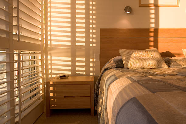 Blinds Beautiful golden light filtering through shutters in bedroom.  window blinds photos stock pictures, royalty-free photos & images