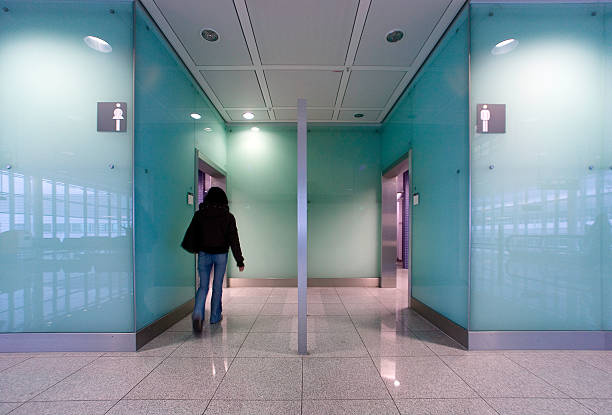 public restrooms a woman walks towards the restrooms. modern architecture made of glass and marble.[ public restroom photos stock pictures, royalty-free photos & images