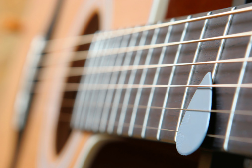 A close-up of the strings of an old acoustic guitar