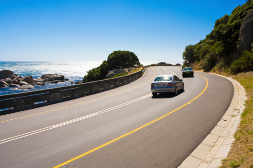 Winding road overlooking a beautiful, bright ocean.Camera: Canon 5D. Unsharpened.