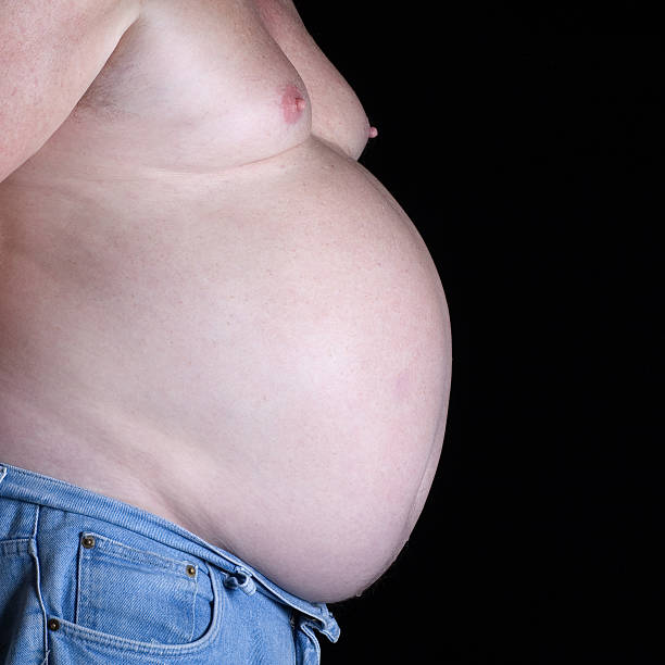 big beer belly man isolated on black stock photo