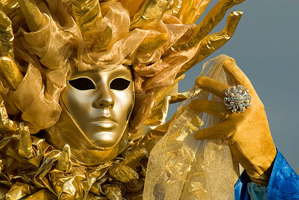 Venice Masquerader Portrait of a Masquerader dressed as the sun at the Venice Carnival, facing into the warm dawn light ostentation stock pictures, royalty-free photos & images