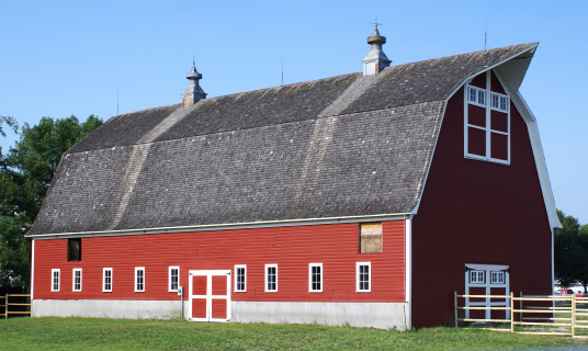 vintage red barn with gambrel roof, two cupolas, and lightning rods