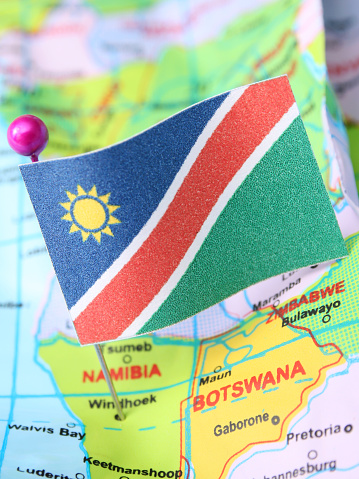 Namibian flag over cheap plastic map pointing Windhoek. Shallow depth of field