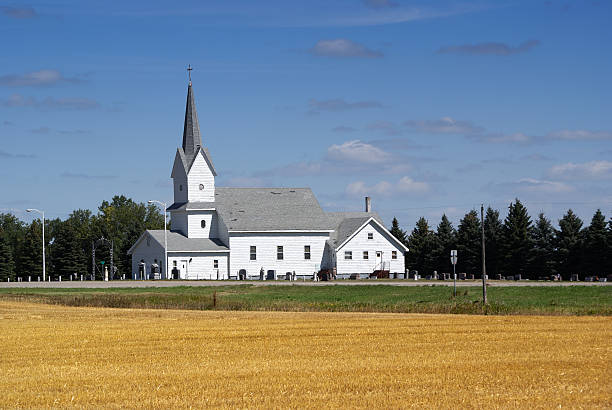 Country church with harvested wheat field in foreground.  Location: North Dakota USA