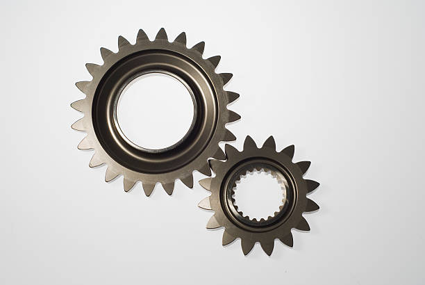 Two steel gears in mesh isolated More engineering images. bicycle gear stock pictures, royalty-free photos & images