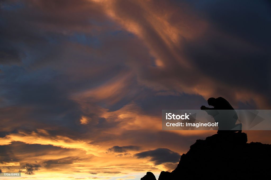 Silhouette d'un homme Agenouillé et prier sur la montagne - Photo de Prier libre de droits