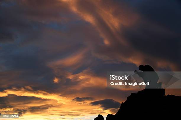 Silhouette Di Un Uomo In Ginocchio E Pregare In Montagna - Fotografie stock e altre immagini di Pregare