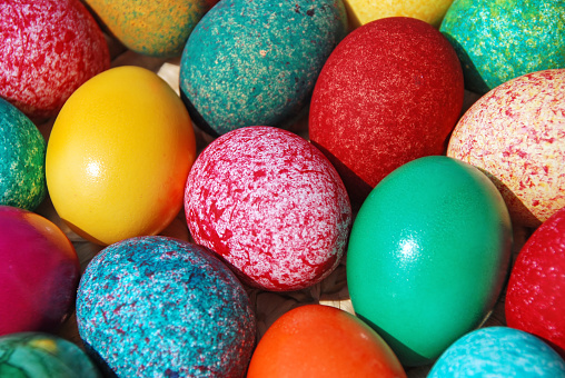 Painted Easter eggs in a basket and tulips. Copy space