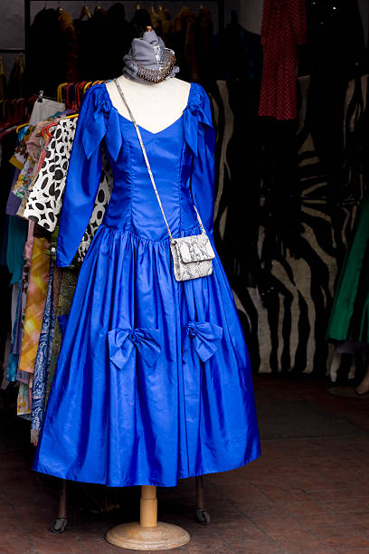 An old fashioned ball gown on a tailor's dummy, on a second hand clothes stall at a flea market.