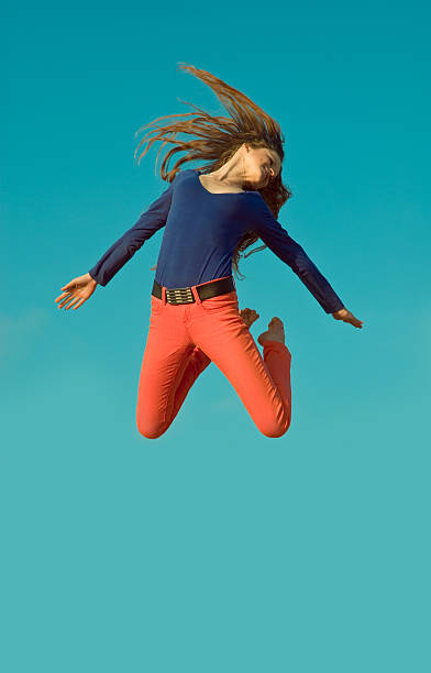 istock jumping girl on blue sky background 170616853