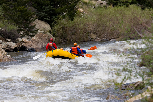 Rafters negotiate the category 5 whitewater of Clear Creek Colorado on a beautiful early summer afternoon as the snow pack in the high country begins to melt in earnest.