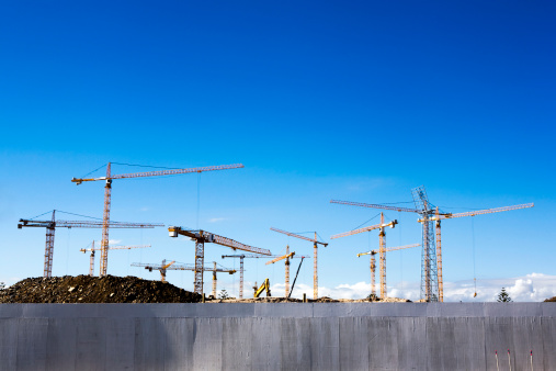 Thirteen cranes visible in this shot of a rush-job construction site.Green Point Stadium in Cape Town, South Africa, is being rebuilt from scratch for the 2010 Soccer World Cup.Camera: Canon 5D with L-series lens.More cranes and construction sites: